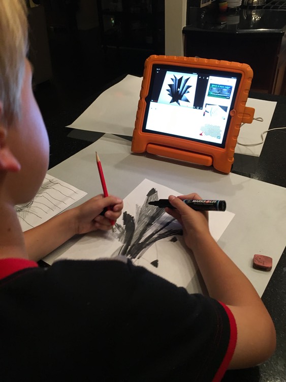 Carter using some YouTube how-to videos to do some drawing